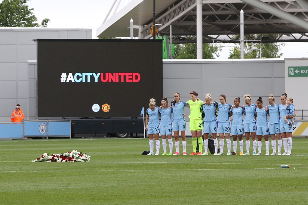 Man City Women stand together during a minute's silence prior to their game against Arsenal Ladies