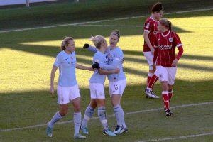 Claire Emslie (left) and Jane Ross (right) congratulate Izzy Christiansen on her successful penalty against Bristol City Women