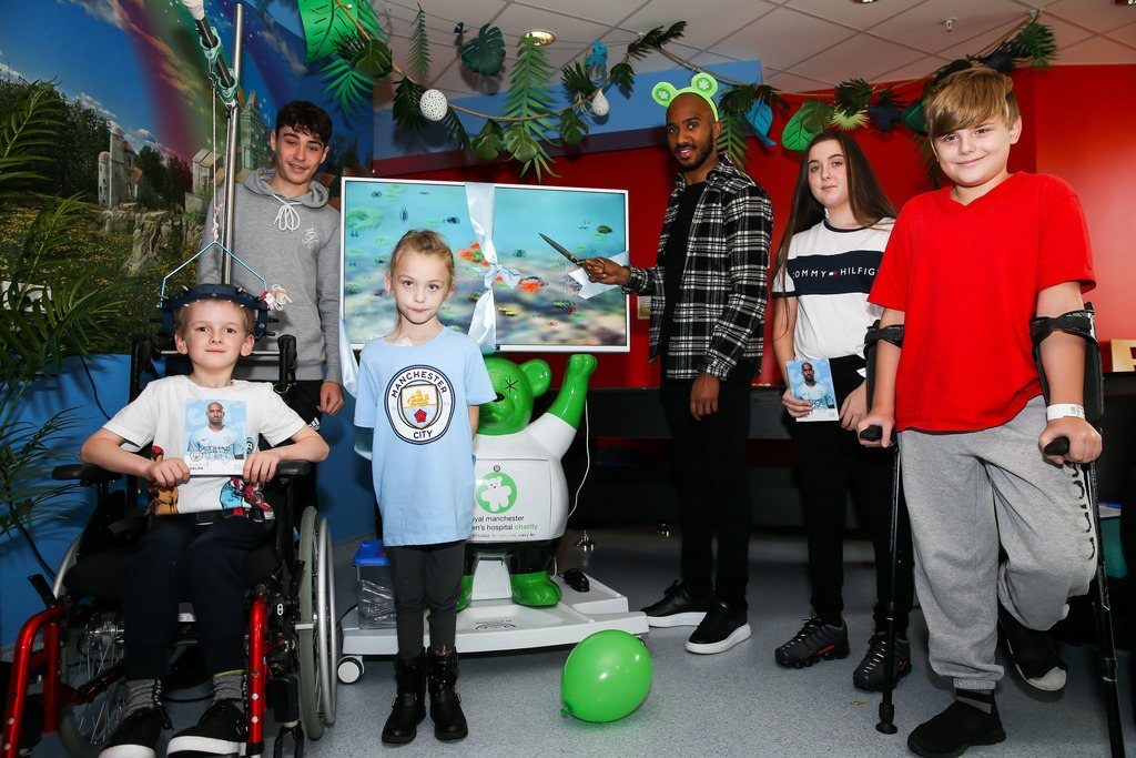 Fabian Delph unveiling 3D pain distraction unit with patients from the Royal Manchester Children's Hospital