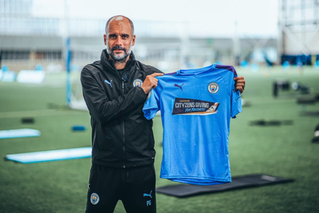 Pep Guardiola with Etihad Cityzens Giving for Recovery Man City shirt