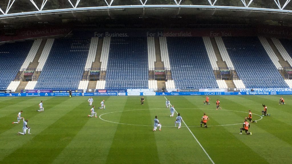 Huddersfield Town and Luton Town players take the knee before their Championship game on Friday, July 10, 2020.