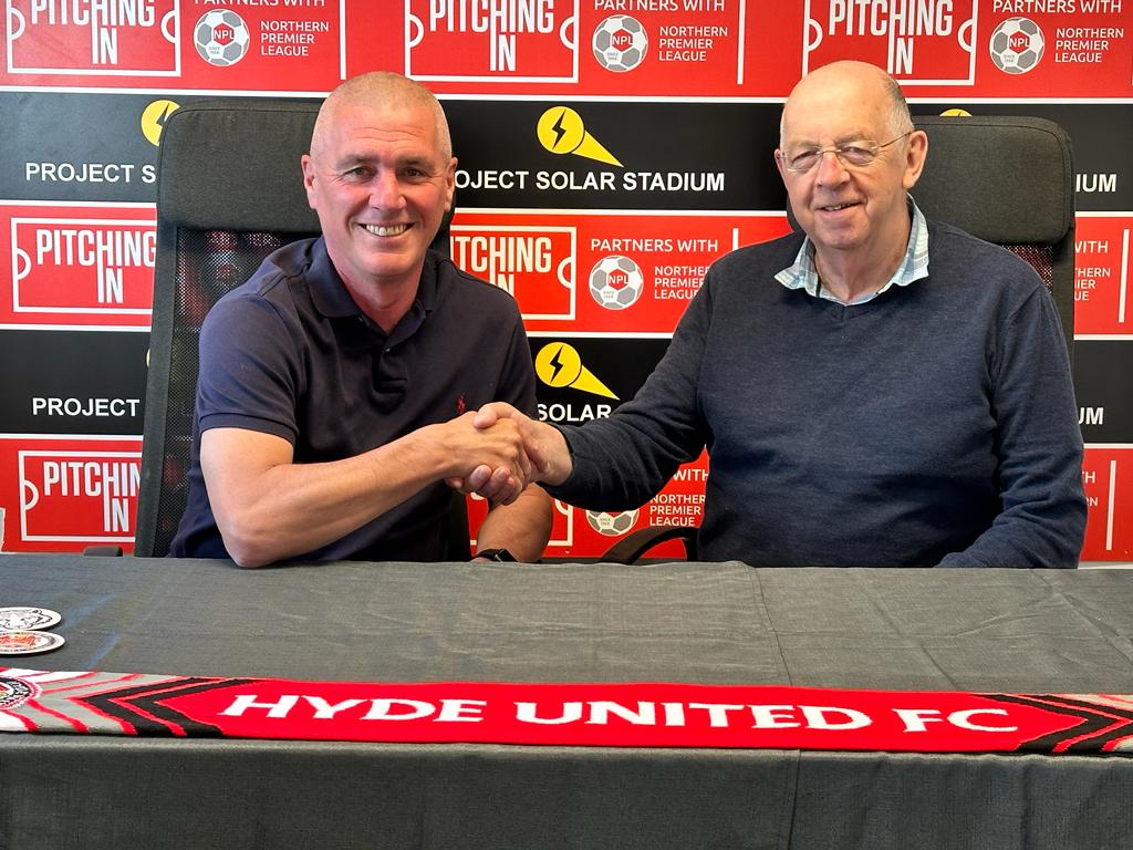 Nick Spooner, left, shakes hands on new deal with chairman Steve Hartley